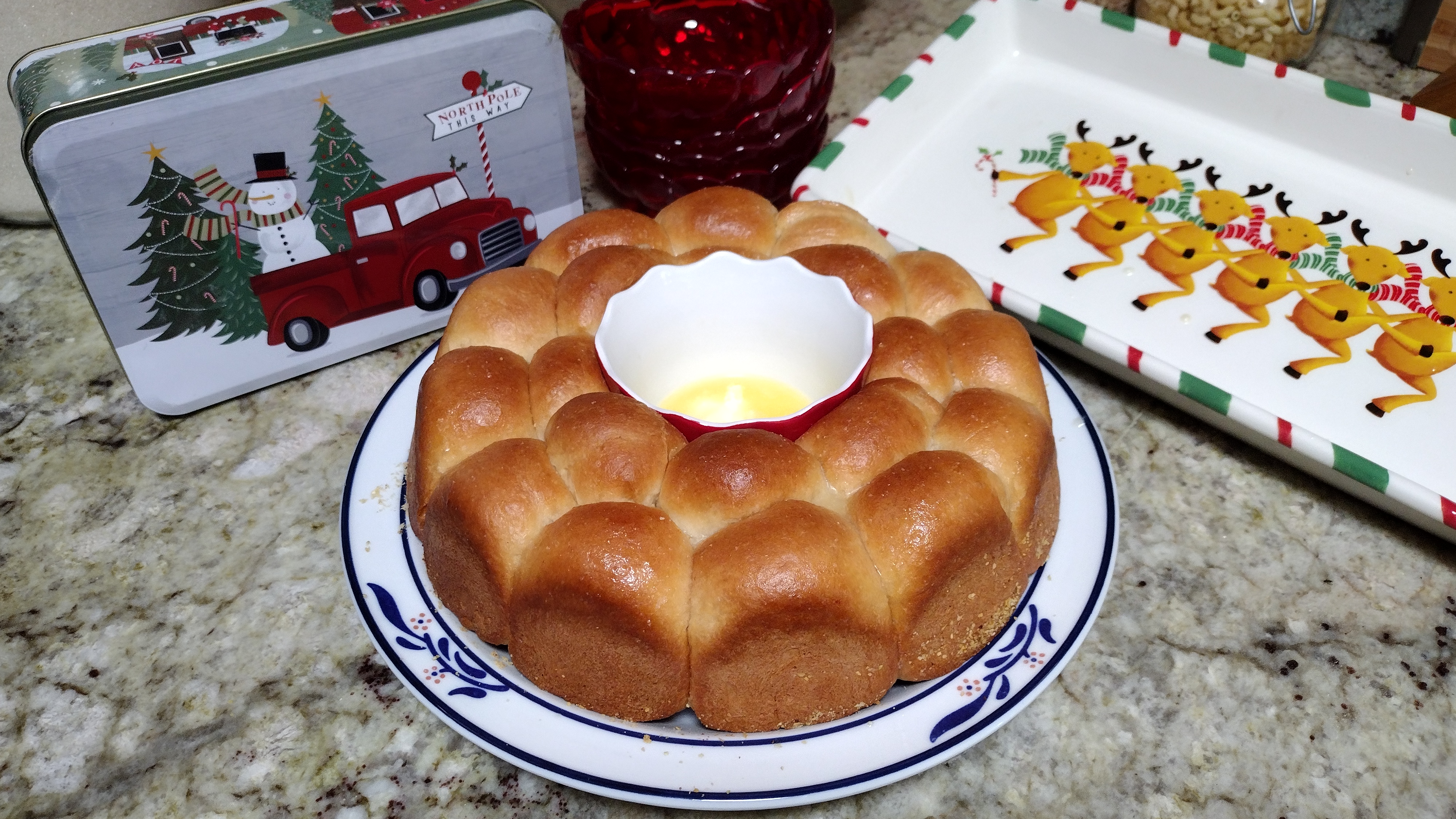 Plate of garlic pull apart rolls with a dish of butter in the center