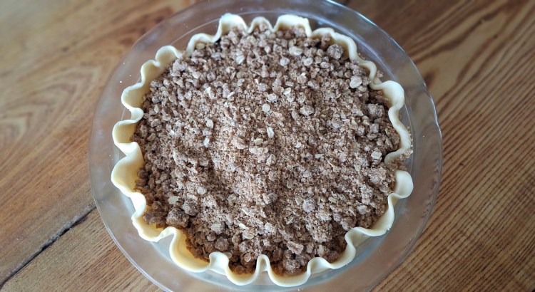 Blueberry pie with crumble topping prepped for baking