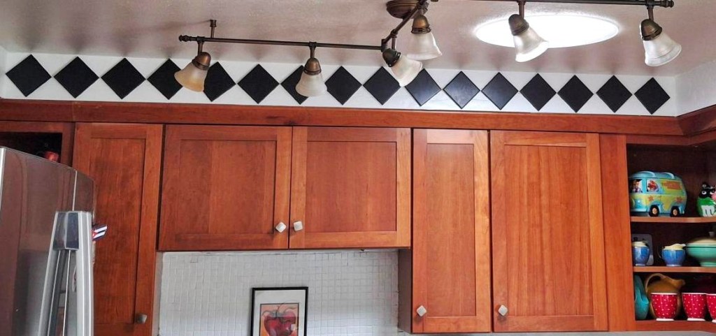 Kitchen cupboards with new black tile on the soffits