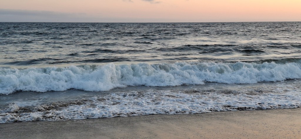 sunset on Santa Monica beach as waves crash to shore