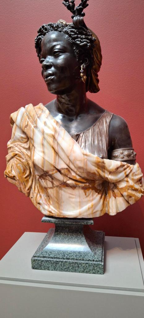 Beautiful sculpture of a Black woman in a striped wrap. All in marble