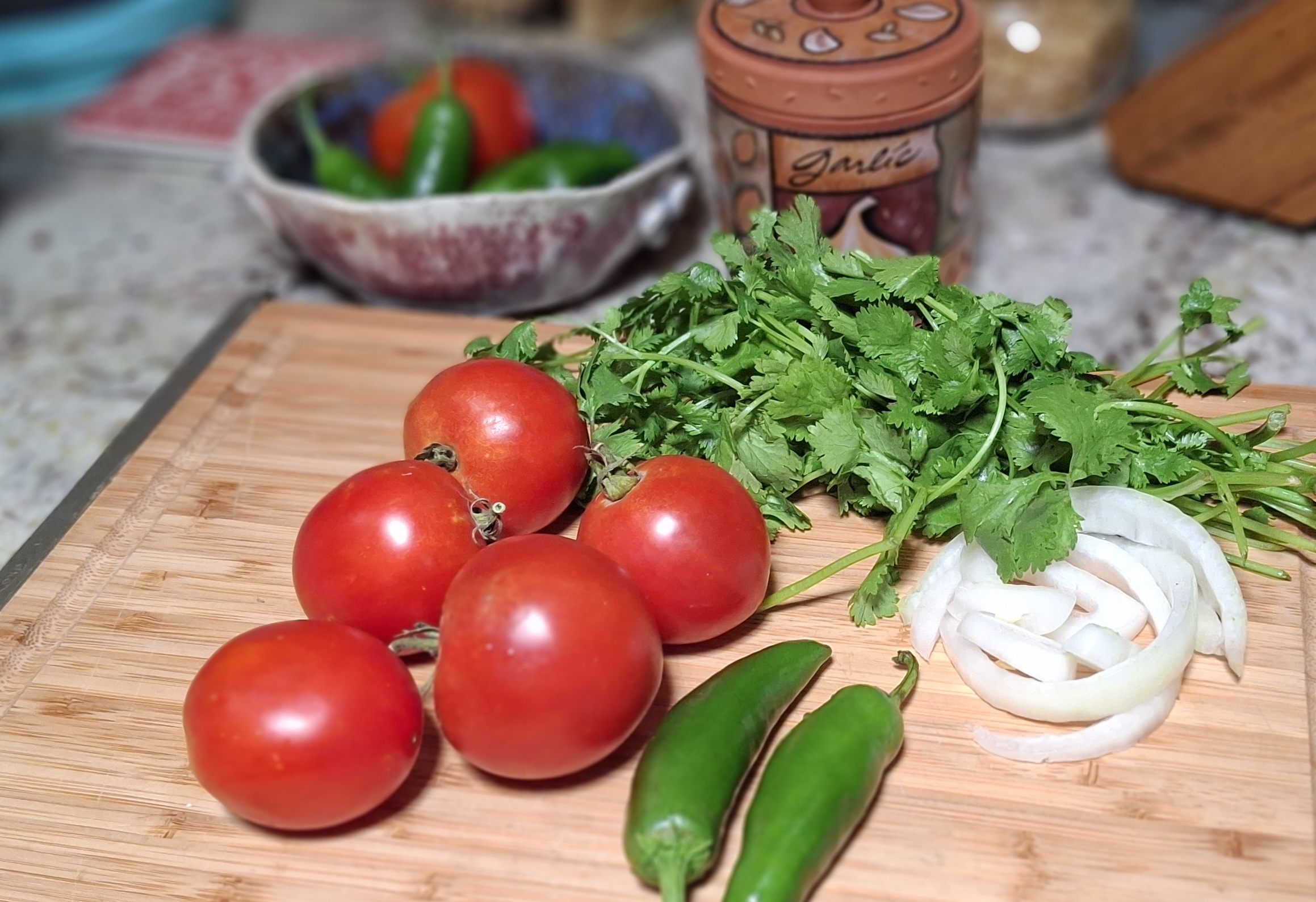 tomatoes, jalapenos, cilantro, onions on a cutting board