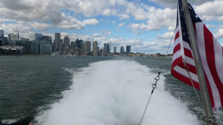 breaking waves from ferry looking out to Boston skyline